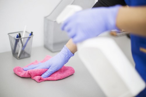 Office cleaners sanitising desks and shared surfaces in Bromley